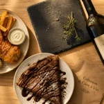 Le cabanon et sa cave à vin à Lacanau : table avec assiette et bouteille