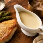 Sauces au vin blanc crémeuses nappant le poisson, verre de vin blanc sec