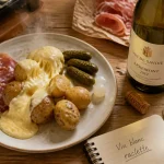 Vin blanc avec la raclette en Savoie, Alsace ou Jura : verre et bouteille de vin blanc sur table