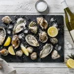 Vin blanc pour fruits de mer, verre et bouteille, huîtres et citron