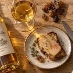 Monbazillac vin blanc liquoreux doré, verre et foie gras sur table en bois